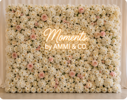 Ivory and blush flower wall with Moments by AMMI & Company LLC logo