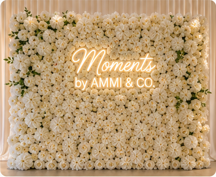 Ivory flower wall with Moments by AMMI & Company LLC logo