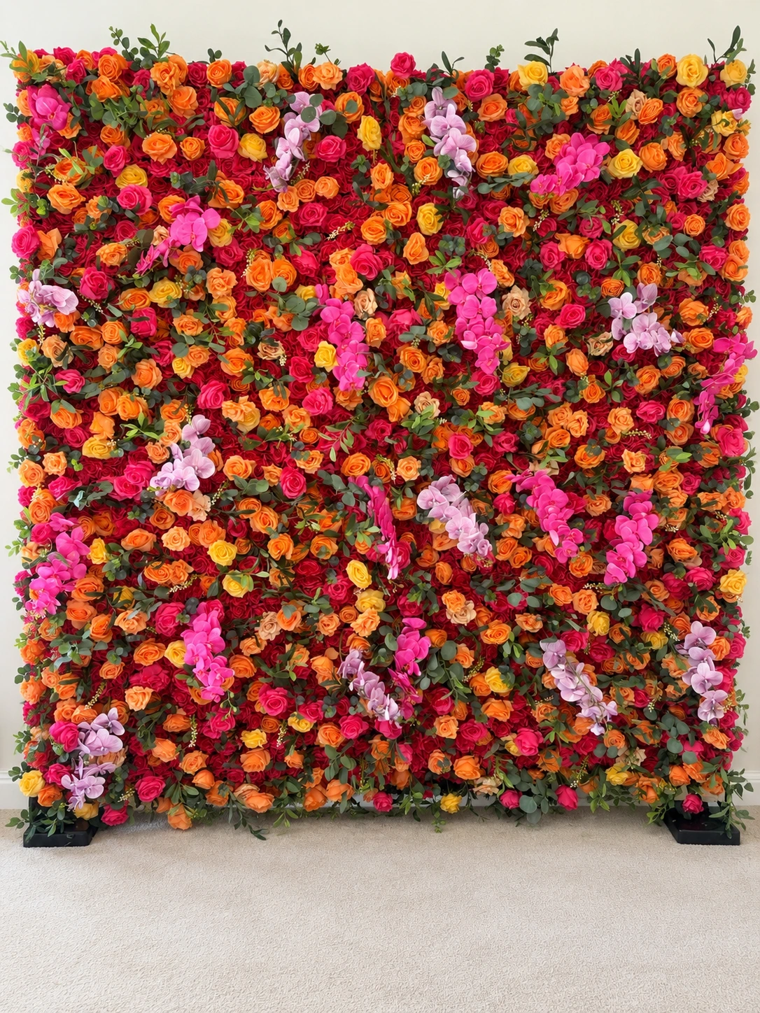 Sunset Flower Wall with vibrant pink, orange, yellow and red roses, orchid accents and greenery